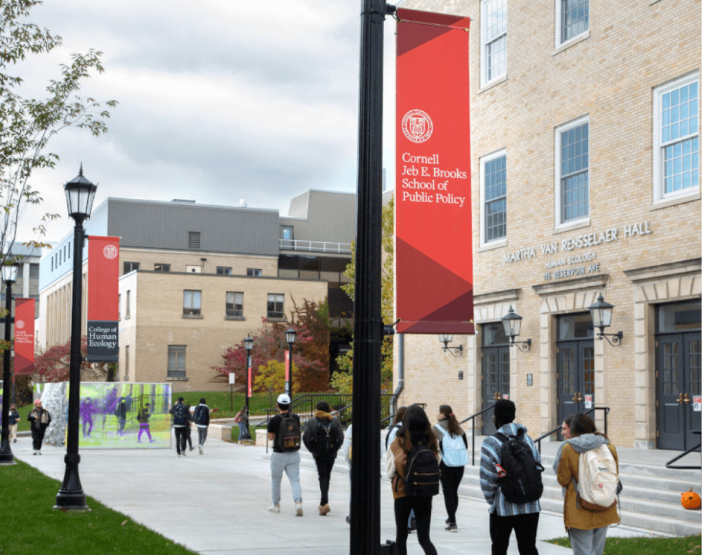 This photo shows an students walking by the Jeb E. Brooks School of Public Policy on Cornell University's Ithaca campus.