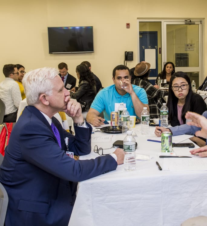 This image shows attendees at a CCHEq roundtable event actively listening to discussion.